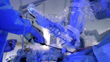 Robot kol forsepsi ve tıbbi aletler bir hastanın karnına girilir. İnsan ve robotun iş birliği.