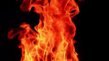 Sarı ve turuncu alevler karanlıkta hareket eder. Şenlik ateşinin üst kısmı gece yanıyor. Kapat..