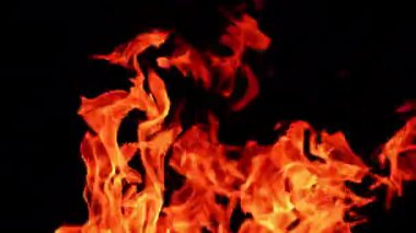 Karanlıkta dans eden şenlik ateşinin kırmızı alevleri. Geceleri yanan kamp ateşinin manzarasını kapat..