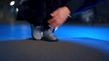 Tanınmayan erkek bebek gri spor ayakkabı giyiyor ve küçük adımlar atıyor. Kapatın. Küçük çocuk yürümeyi öğreniyor..