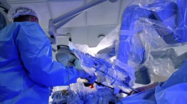 Da Vinci robotu ve erkek cerrah ameliyat yapıyor. Modern hastanede minimal invaziv cerrahi düşük açılı görüş.
