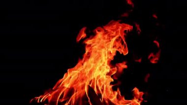 Büyük kamp ateşi gecenin karanlığında yükseliyor. Tehlikeli alevler rüzgara karşı yan yatar.