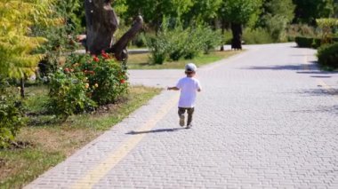 Parktaki ara sokakta koşan küçük bir oğlanla arayı kapatıyorum. Küçük çocuk ahşap bir heykele yaklaşır..