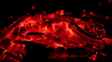 Parlak parlak alevlerle dolu bir kor yığını. Yanmış şenlik ateşinin yakın görüntüsü.