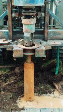 Yerdeki çamurlu su birikintisinde büyük bir kuvvet var. Kürek makinenin çalışmasına yardımcı oluyor. Sıkıcı bir süreç. Dikey video.