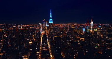 New York 'un ünlü gökdelenlerinin keskin tepeleri Metropolis' in panoramasında duruyor. İnsansız hava aracından gece şehir manzarası.