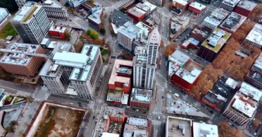 Smith Tower gökdeleni, Amerika Birleşik Devletleri Seattle 'ın Pioneer Meydanı mahallesinde. İnsansız hava aracı görüntüleri gündüz manzaranın üzerinde daireler çiziyor..