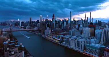 Alacakaranlıkta New York 'ta, Doğu Nehri' nin yukarısında. Yat, Queensboro Köprüsü 'nden denize açılıyor..