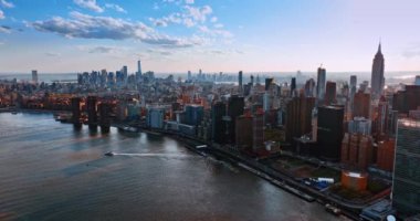 Motorlu tekne New York 'un doğu nehri kıyısından uzaklaşıyor. Metropolis gün batımında tepeden ufuk çizgisi.