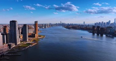 New York 'ta East River' ı geçen modern bir motorlu tekne. Gündüz insansız hava aracından muhteşem şehir silueti.