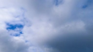 Kalın beyaz bulutlar gökyüzüne yayılıyor. Gök mavisi gökyüzünü kaplayan hızlı uçan bulutlar. Zaman Uygulaması.