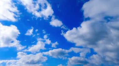 Rüzgarda hızla süzülen küçük bulutlar ile şaşırtıcı masmavi gökyüzü. Yaz gökyüzüne düşük açılı bir bakış açısı. Zaman Uygulaması.