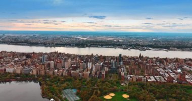 Nehrin pürüzsüz çizgisi New York 'un kentsel manzarasını geçiyor. Hava aracı günbatımında Central Park 'ın üstünde..