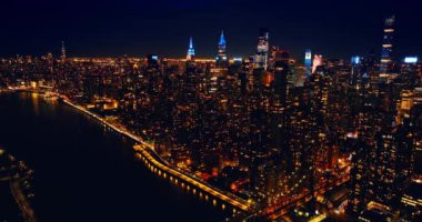 Geceleri New York 'un göz kamaştırıcı manzarasına iniyor. Karanlık Doğu Nehri metropolün aydınlık şehir manzarasından akıyor..