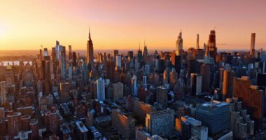 New York şehir merkezindeki çeşitli binaların cephelerini kaplayan güneşin batışının pembe ışığı. Metropolis 'in altın saatindeki göz kamaştırıcı manzarası.