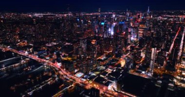 Geceleri New York 'un hareketli otoyollarında trafik sıkışıklığı. Milyonlarca araba şehrin iyi aydınlatılmış yollarından geçiyor. Hava görünümü.