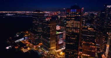Geceleri ışıl ışıl New York manzarası. Doğu Nehri 'nin karanlık suları parlak ışıkla göz kamaştıran şehir manzarasından farklıdır. Hava görünümü.