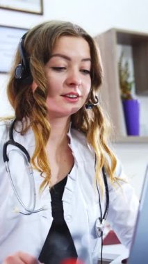 Coronavirus, tıbbi personel laptop 'daki modern webcam teknolojisini kullanarak sağlık standartlarından bahsediyor. Mikrofonlu güzel bir sağlıkçı kadın. Dikey video