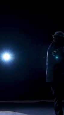 Karanlıkta sahnede kostümlü son sınıf öğrencisi. Tiyatrodaki gösteri sırasında sahnede dans eden şapkalı aktif bir adam. Dikey video