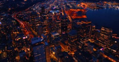 Geceleyin aydınlık bir şehir manzarası. Geniş çok şeritli otoyol arabalarla doludur. Seattle, Washington State, ABD 'nin panoramasına hava perspektifi.