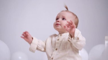 Güzel beyaz çocuğa ipli bir paket veriliyor. Sevimli bebek onunla oynayarak tomarla para kazanıyor. Beyaz arkaplan.