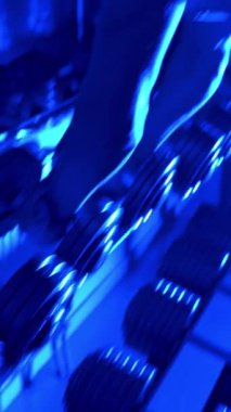 Beden dersinde aptal bir adam. Kas yapan bir adam spor salonunda halterlerle antreman yapıyor. Dikey video