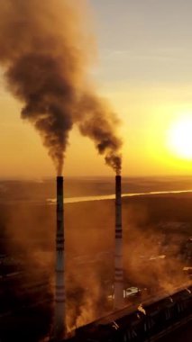 Pipo fabrikası gibi. Gün batımında enerji santrali boruları tüttürmek. Dikey video