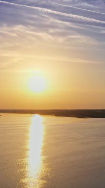 Nehrin üzerinde gün batımı manzarası. Gün batımının hava görüntüsü. Zaman nehri ufku. Dikey video