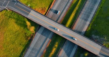 Araba iki otoyolun üstündeki otoyoldan geçiyor. Yolların etrafında büyüyen yeşil çimenler. Üst görünüm.