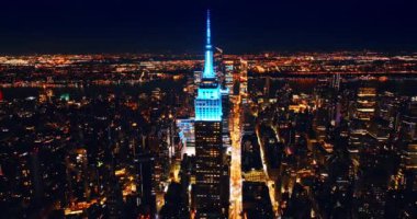 Empire State Binası, güzel aydınlatılmış, mavi neon ışıklı. Gece yoğun trafiği olan parlak sokaklar. Üst görünüm.