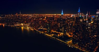 New York, New York 'ta Manhattan' a yakın East River 'ın üzerinde uçuyor. Geceleri metropolün göz kamaştırıcı manzarası.