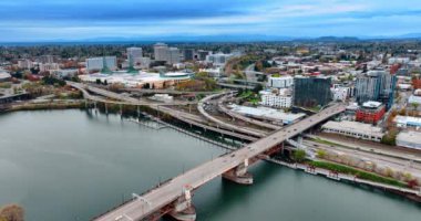 Portland, Oregon, ABD 'deki Willamette Nehri üzerindeki köprü. Arabalar rıhtımdaki yollar ve otobanlardan hızla geçiyor. Kasvetli bir günde şehir manzarası.