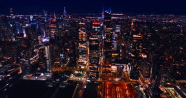 Geceleri hiç uyumayan göz kamaştırıcı New York. Işıklarla dolu uçsuz bucaksız metropol manzarasına hava perspektifi.