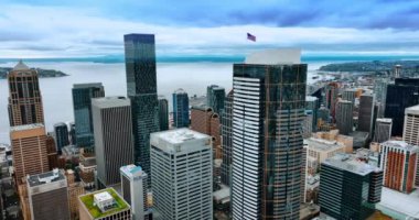Seattle, Washington, ABD şehir merkezinde ayna cepheli güzel binalar. Rüzgarda dalgalanan Amerikan bayrağı. Arka planda göl var. Üst görünüm.