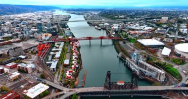 Portland, Oregon, ABD 'deki Willamette Nehri' ndeki köprülerin üzerinden uçuyor. Şehrin engin manzarası. Dağlar ve arka planda bir sürü yeşillik var..