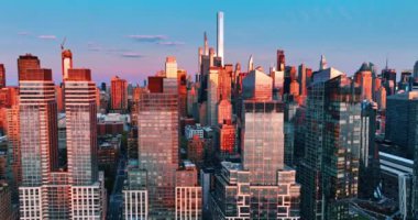 Metropolis şehir merkezinde gün batımında pembe ve mavi ışığın karışımı. New York 'taki yüksek binalar boyunca İHA uçuşu.