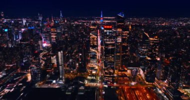 Metropolis gece ışıldayan ışıklarla dolu. Birden fazla nakliye aracının geçtiği aydınlık sokaklar. Üst görünüm.