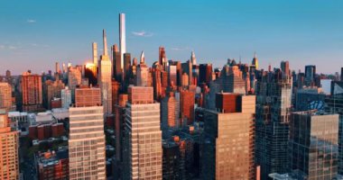Batan güneşin turuncu ışığı muhteşem New York gökdelenlerinin cephelerine yansıyor. Şehir merkezindeki en yüksek binalara yaklaşıyoruz..