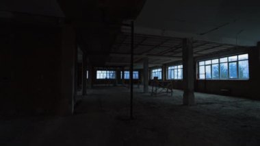 Büyük pencereleri ve sütunları olan büyük bir oda. Tamamlanmamış duvarları, tavanı ve zemini olan bir bina..