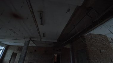Tavan, eski binada büyük bir dayanak noktası. Tavanda alçak açı görünümü ve birden fazla kablo asılı..