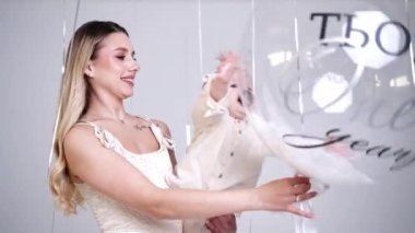 Anne bebeğini elinde tutuyor. Neşeli çocuk büyük balonu yakalar. Stüdyo görüntüleri.