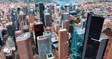 Merkezinde muhteşem gökdelenler olan Seattle şehir merkezinin üzerinde uçuyor. Şehir manzarasında göller birliği var.