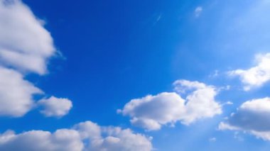 Açık beyaz bulutlar güzel gök yüzünde dönüşür. Bulutların alçak açısı güneşle aydınlanır. Zaman Uygulaması.