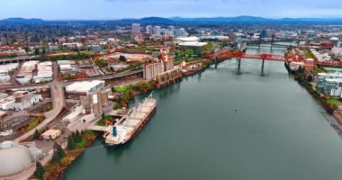 Büyük feribot Portland, Oregon, ABD 'deki Willamette Nehri' nin rıhtımında duruyor. Havadan insansız hava aracı Broadway Köprüsü ve Çelik Köprüsü 'ne yaklaşıyor..