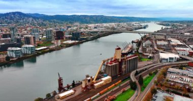 Portland 'ın şehir manzarası Willamette Nehri ile bölündü. Su manzarasının üstündeki Fremont Köprüsü 'ne bakın. Arkaplanda dağ aralığı.