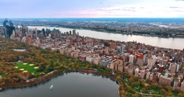Gündüz vakti New York 'taki Central Park' ın güzel manzarası. Göletin yukarısındaki drone görüntüleri şehrin ve Doğu Nehri 'nin engin manzarasını gözler önüne seriyor..