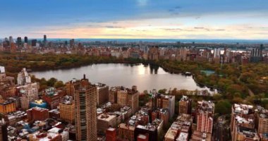New York, Central Park 'taki renkli sonbahar ağaçlarıyla çevrili büyük gölete yaklaşıyoruz. İHA 'dan Metropolis Manzarası.