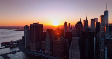 New York 'ta ufukta güneş batıyor. Metropolis gökdelenleri parlak turuncu ışıkla aydınlatılır. Hava görünümü.