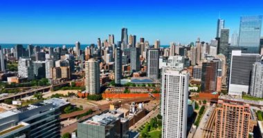 Güneşli bir günde modern Chicago 'nun güzel şehir manzarası. Arkaplandaki gökdelen grubuna yaklaşan binaların üstündeki drone görüntüleri..