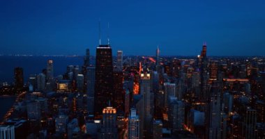 Chicago akşamları ışıkları açıyor. İnsansız hava aracı şehrin üzerinde yükseliyor. Aydınlanmış sokakları ve su manzarasını gözler önüne seriyor..